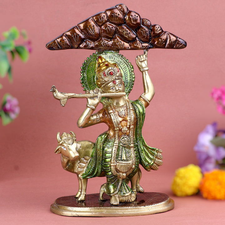 3.9 Inch intricately crafted Brass Krishna Idol depicting Lord Krishna lifting Mount Govardhan with one hand, symbolizing divine protection and strength, ideal for spiritual home décor and devotional worship.  No.1 Brass Idol Store www.satvikstore.in