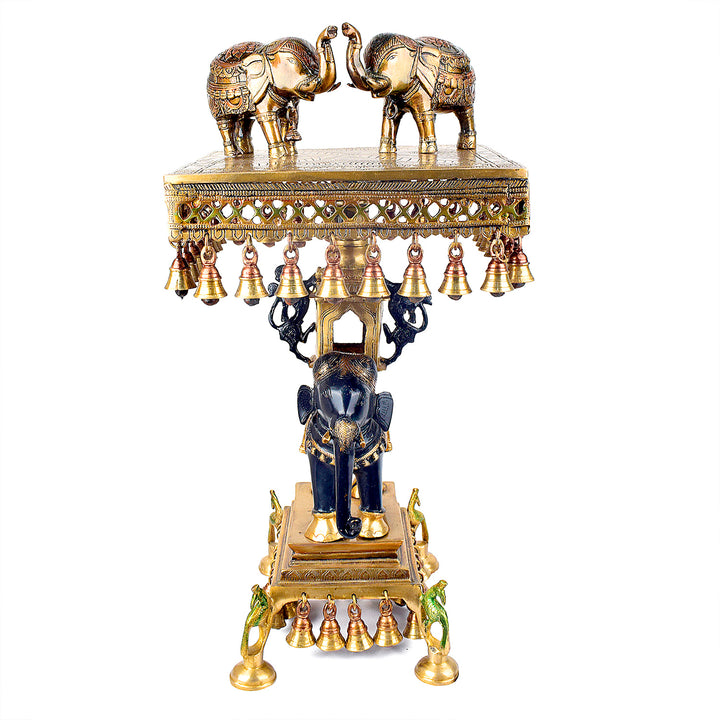 Large Brass Idol of 23 Inch Brass Chowki on Elephant with Hanging Bells. This 23 Inch Brass Chowki on Elephant with Hanging Bells is a stunning blend of artistry and tradition. Crafted from high-quality brass, the intricate detailing of the elephant and the delicately suspended bells add a touch of elegance to any space.