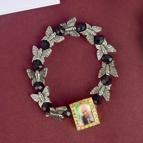Chic Guruji Swaroop Bracelet featuring black beads and silver butterfly charms, handcrafted for spiritual elegance and daily devotion. India’s Largest Pooja Accessories Brand – www.satvikstore.in